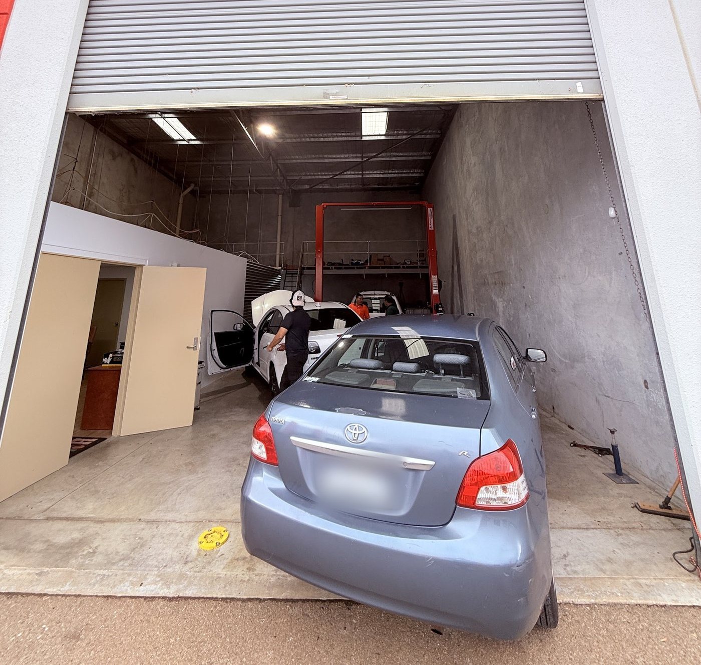 The AutoTrics team working on cars inside the open workshop at Unit 9